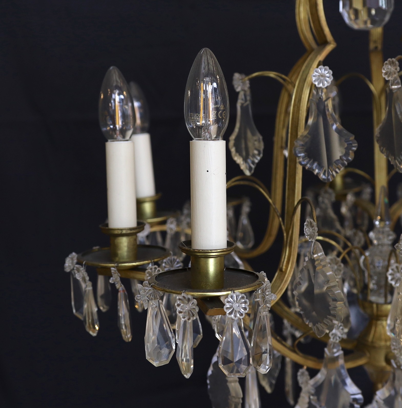 An early 20th century French silver and bronze and cut glass ten light chandelier hung with lozenge and tear shaped drops, drop 82cm. width 60cm